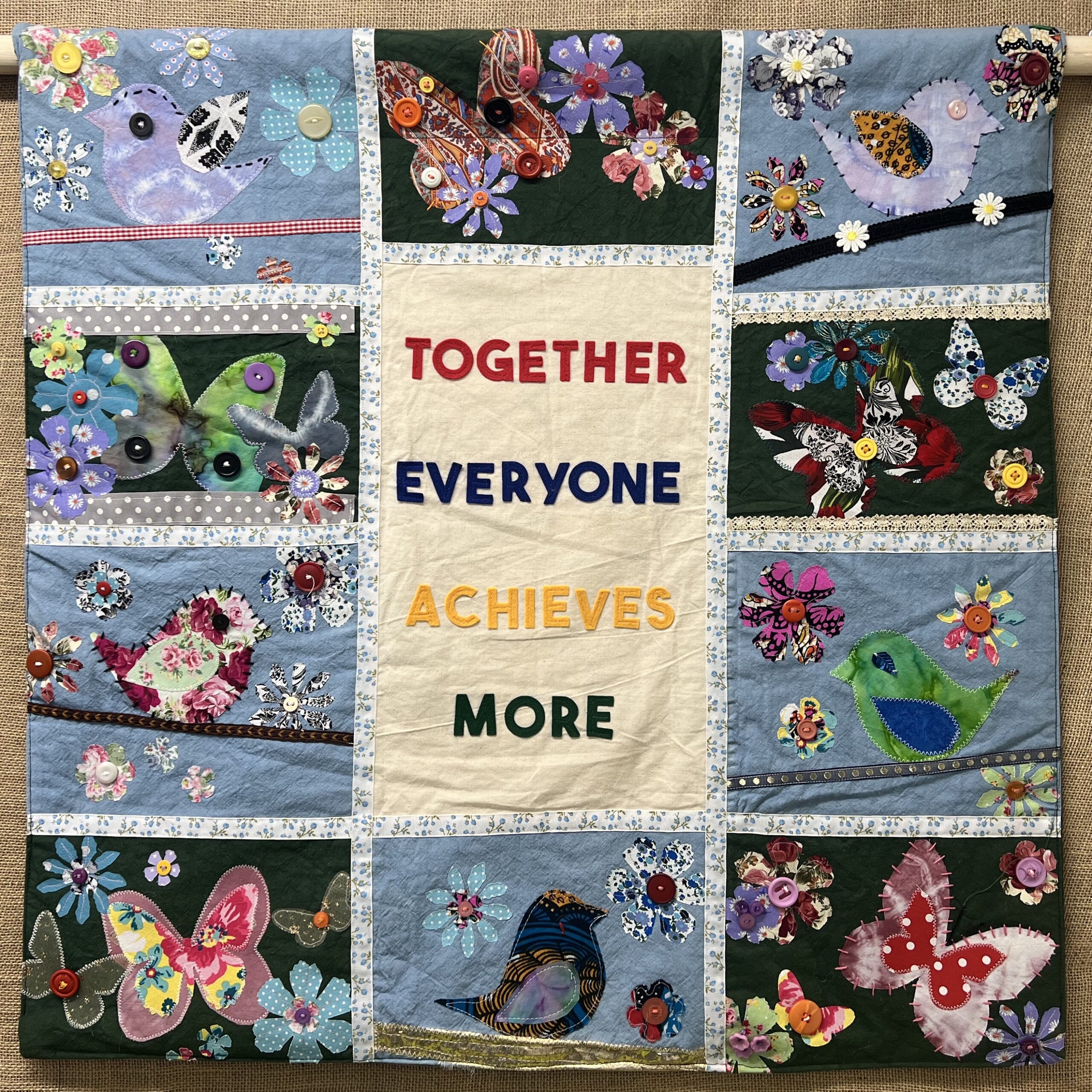 Tapestry with the words Together Everyone Achieves More in colourful appliqué